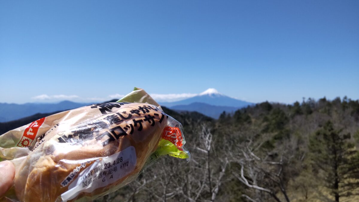 小金沢山山頂で富士山を眺めながらパンを食べる