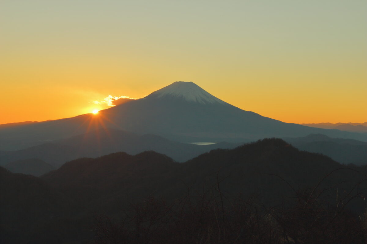 富士山の肩に沈んでいく夕陽