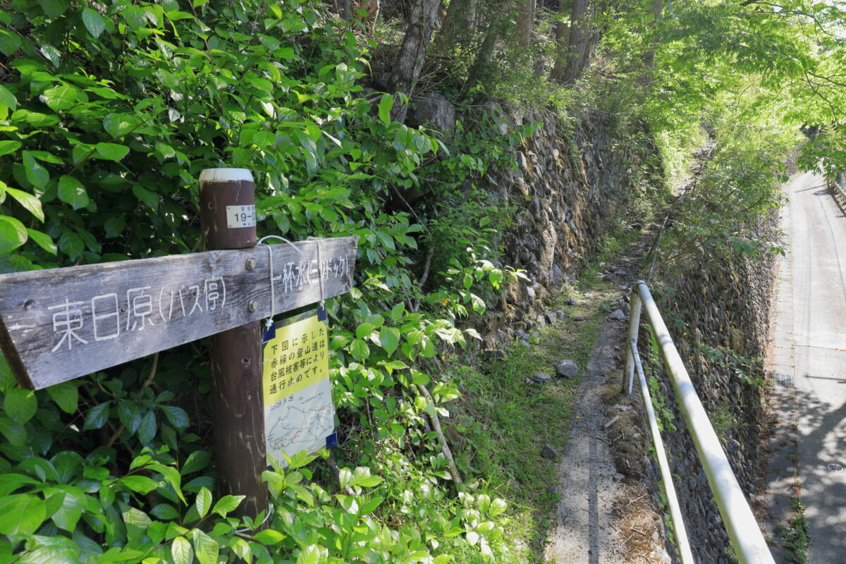 車道の石垣の上を通るヨコスズ尾根への登山口付近の道