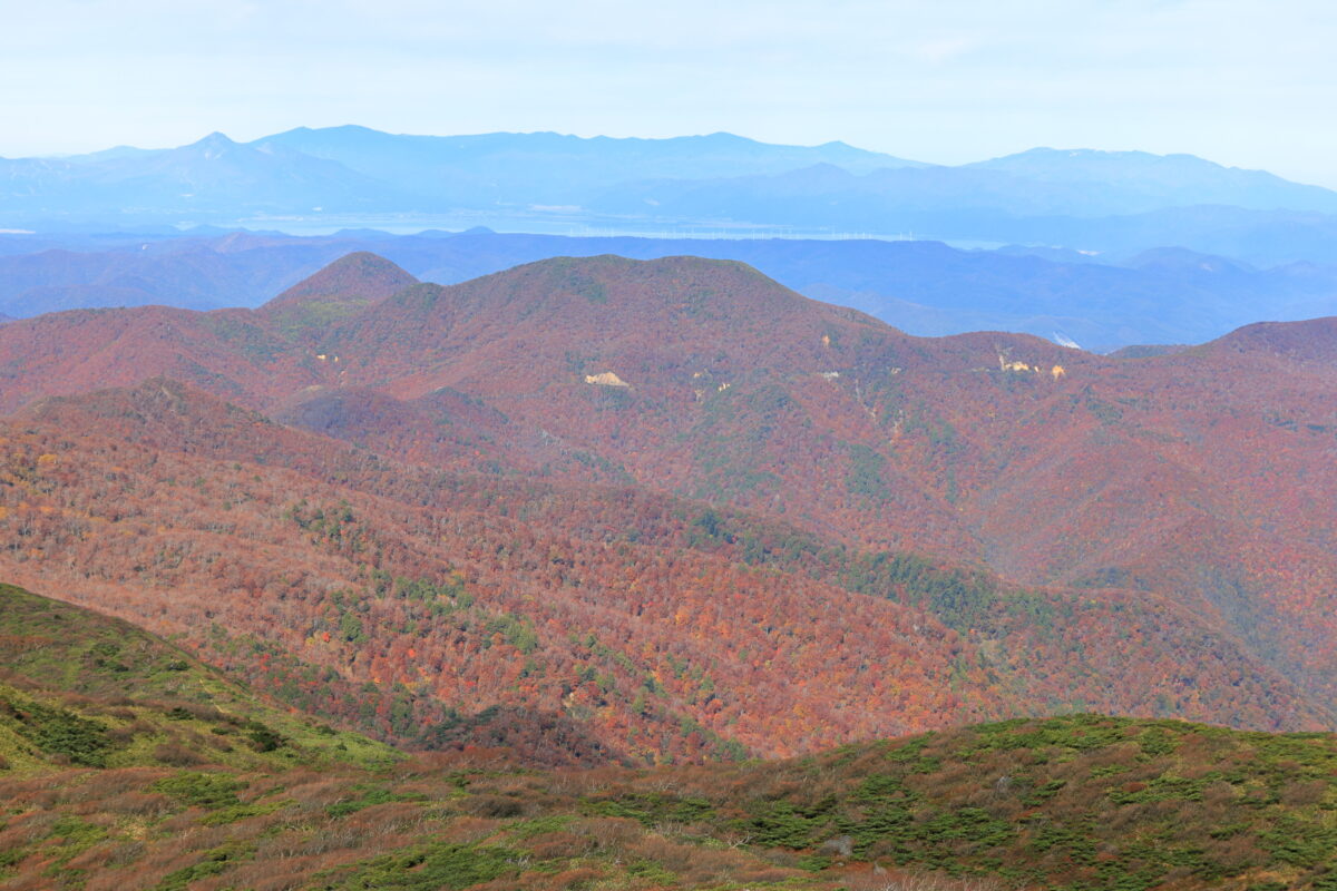 三本槍岳山頂からの猪苗代湖手前の山腹の紅葉の眺め